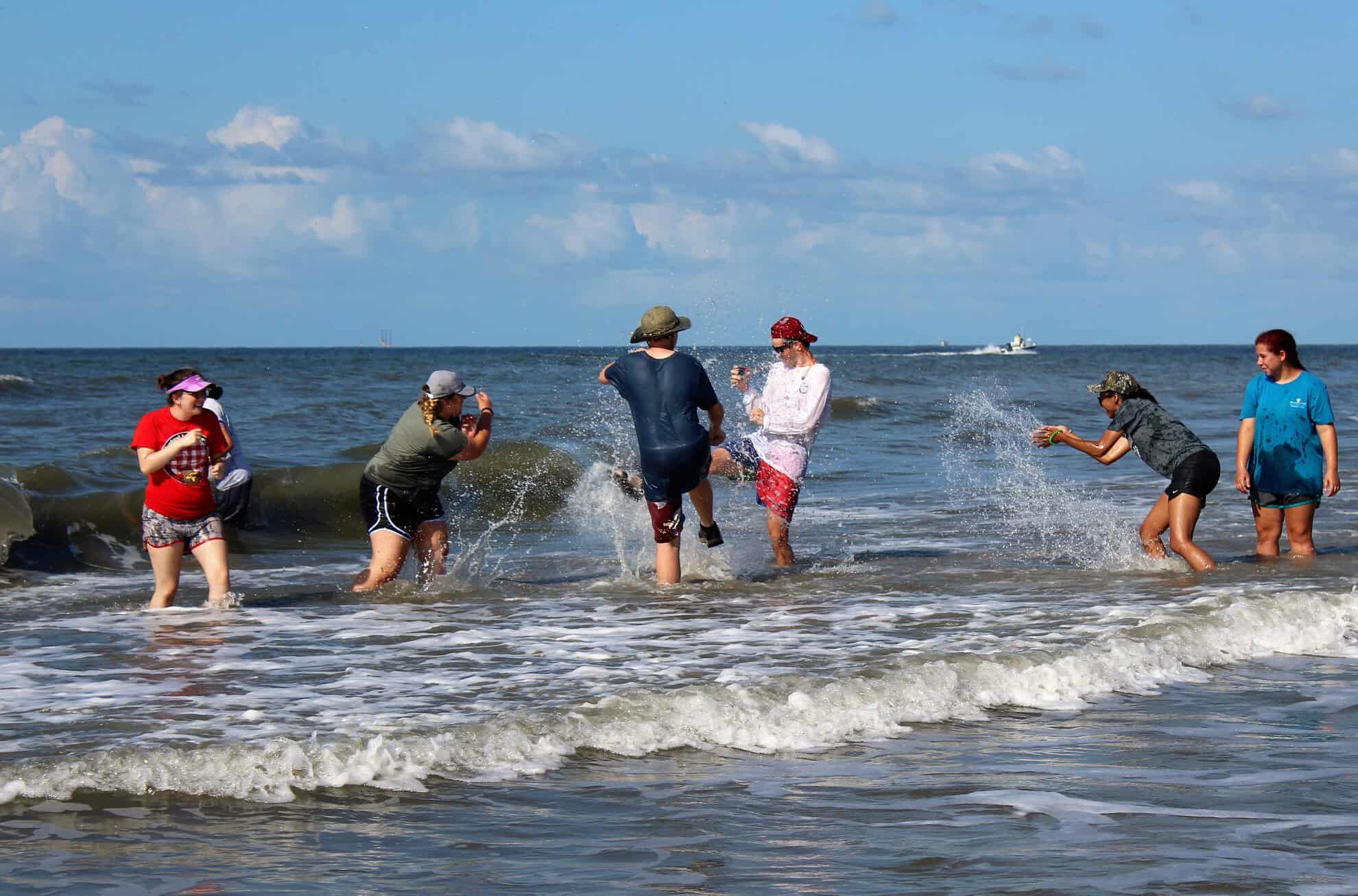 People playing in the water along the coast