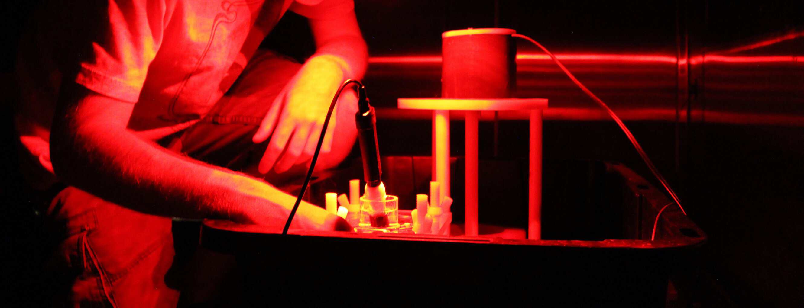 A man working under red lighting