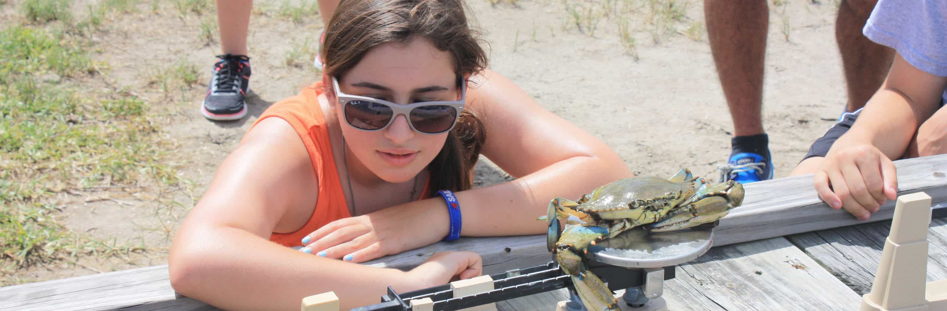A girl interacting with a crab during an activity