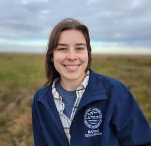 Smiling woman in marine education jacket outdoors at LUMCON.