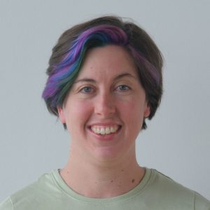 Portrait of Dr. Brianne Du Clos with colorful hair and a friendly smile.