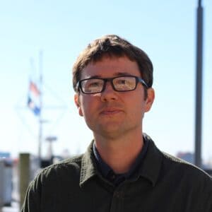Portrait of Kevin Du Clos outdoors with maritime background.